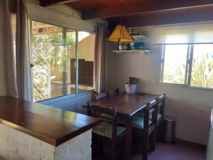 a dining room with a wooden table and a window at La posta de corumba in La Paloma +30 photos