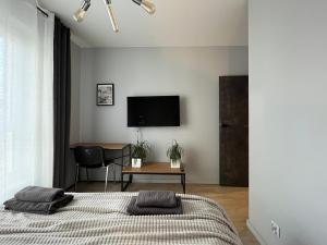 a bedroom with a bed and a tv on the wall at Yellow - Bastion Wałowa EV center free parking in garage in Gdańsk