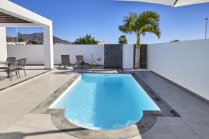 a swimming pool in the middle of a house at Villa Cantium - LH101 By Villas Now Ltd in Playa Blanca