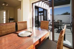 drewniany stół z krzesłami i jadalnia w obiekcie Villa Cantium - LH101 By Villas Now Ltd w mieście Playa Blanca