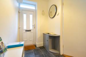 a room with a door and a table and a mirror at Newly-renovated, mid-terrace cottage in Porthmadog in Porthmadog