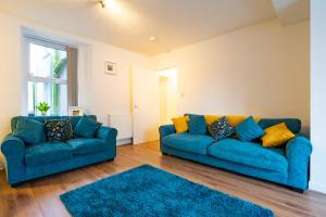 un soggiorno con 2 divani blu e un tappeto di Newly-renovated, mid-terrace cottage in Porthmadog a Porthmadog Altre 35 foto