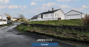 a house on a hill next to a street at Cockermouth - 3 Bedroom, Sleeps 10 Garden - JRR Stays in Cockermouth