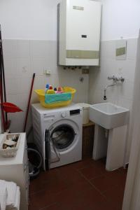 y baño con lavadora y lavamanos. en Mari & Monti en Montignoso