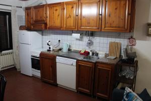 a small kitchen with wooden cabinets and a sink at Mari & Monti in Montignoso