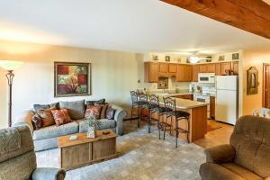 a living room with a couch and a kitchen at Waterfront Port Clinton Condo with Pool Access! in Port Clinton