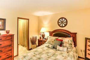 a bedroom with a bed and a dresser and a clock at Waterfront Port Clinton Condo with Pool Access! in Port Clinton