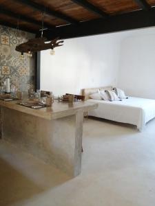 um quarto com uma cama e uma mesa e uma cama sidx sidx em Casa Bizu em Bacalar