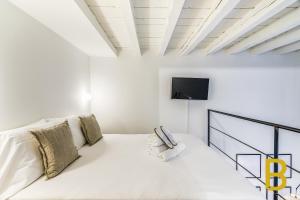 - un salon blanc avec un canapé blanc et une télévision dans l'établissement BePlace Apartments in Gae Aulenti, à Milan