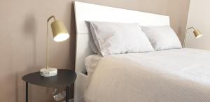 - une chambre avec un lit et une table avec une lampe dans l'établissement Venice & Treviso - ANTHEA design apartments, à Casièr