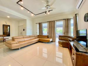 sala de estar con sofá y mesa en BNB Casa Grande at Rawang - spacious, 15 pax and WiFi, en Rawang