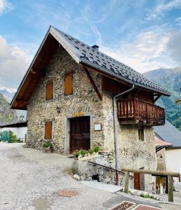 een groot stenen gebouw met een balkon bij La Grange St. Cyprien, Venosc - Les Deux Alpes in Vénosc