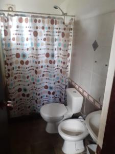 une salle de bain avec toilettes et rideau de douche dans l'établissement La posta de corumba, à La Paloma 29 autres photos
