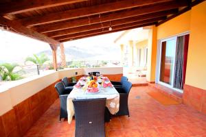 una mesa con sillas y comida en el patio en Villa with private pool and magnificent views, en Adeje