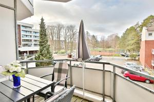 un balcone con tavolo e ombrellone di Residenz Ostseestrand Appartement 4 a Scharbeutz