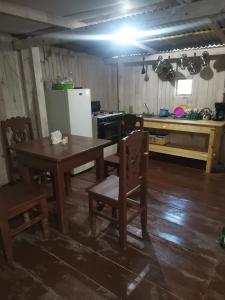 a kitchen with a table and chairs and a refrigerator at Casa del bosque 