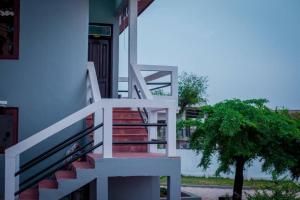 a staircase leading to a house with a tree at Patayo Lodge in Kumasi