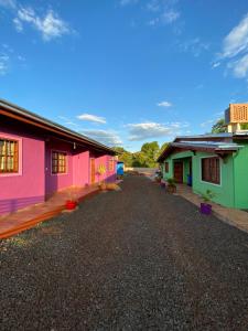 uma fila de casas coloridas numa estrada de cascalho em Cabañas Aranderay em Puerto Esperanza