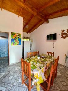 a dining room with a table with chairs and a television at Cabañas Aranderay in Puerto Esperanza