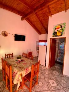 uma sala de jantar com uma mesa e cadeiras e uma televisão em Cabañas Aranderay em Puerto Esperanza