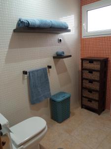 a bathroom with a toilet and a blue towel at OceanView Apartment in La Manga del Mar Menor
