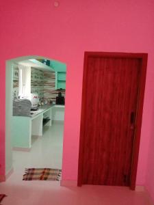 ポンディシェリにあるThendral homes 1BHKのピンクの部屋の赤いドア