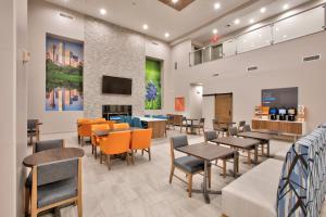 a dining room with tables and chairs and a tv at Holiday Inn Express & Suites North Dallas at Preston, an IHG Hotel in Dallas