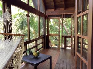 un porche en una casa en un árbol con una hamaca en Tropical Treehouse en Sandy Bay