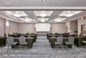 una sala de conferencias con mesas, sillas y una pantalla en Holiday Inn Express & Suites North Dallas at Preston, an IHG Hotel, en Dallas