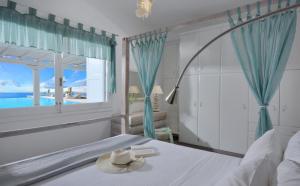 sypialnia z łóżkiem i widokiem na ocean w obiekcie Luxurious Villa in Mykonos with Pool w mieście Agios Ioannis