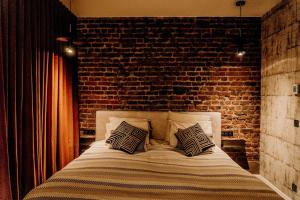 a bed in a room with a brick wall at Fiertelmeers Boutique B&B in Ronse
