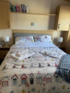 a bed with a blanket on top of it at Holiday home at cherry tree holiday park Burgh castle Great Yarmouth Norfolk in Great Yarmouth +13 photos