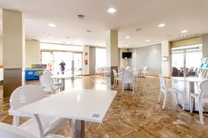 a dining room with white tables and white chairs at Hotel Castilla Alicante in Alicante