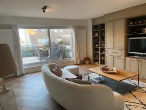 a living room with a couch and a table at Residentie Zeebries, luxe en ruim appartement met zijzicht op zee in Knokke-Heist