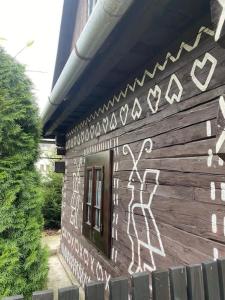 un edificio con graffiti a un lado en Maľovaná drevenička v Čičmanoch en Čičmany