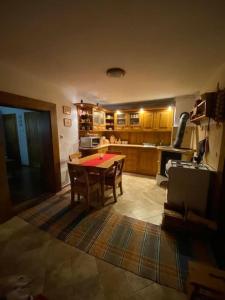 a living room with a table and a kitchen at Maľovaná drevenička v Čičmanoch in Čičmany