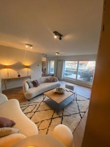 a living room with a couch and a coffee table at Residentie Zeebries, luxe en ruim appartement met zijzicht op zee in Knokke-Heist