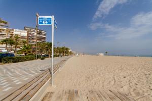 a street sign on a sandy beach with condos at Hotel Castilla Alicante in Alicante