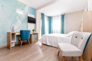 a bedroom with a bed and a desk and a chair at Hotel Castilla Alicante in Alicante
