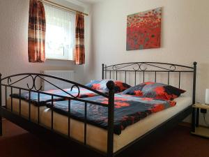 een slaapkamer met een zwart bed met kussens en een raam bij Ferienwohnung Grieser in Geising