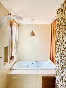 a bath tub in a bathroom with a window at Villa Mar Residence in Jericoacoara