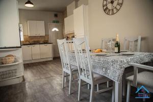 una cocina con mesa con sillas y una botella de vino en Spacious and Homely 3 Bedroom Flat - SuiteLivin en Gateshead