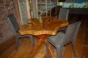 una mesa de comedor de madera con 4 sillas alrededor en Hospedaje SELVA DE AVES, en Leticia