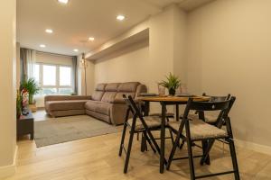- un salon avec une table, des chaises et un canapé dans l'établissement Orzan Beach by Urban Flats, à La Corogne