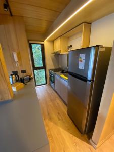 a kitchen with a stainless steel refrigerator and wooden floors at VIVERO 5 SMA in San Martín de los Andes