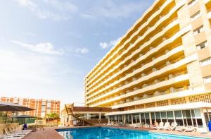 a hotel with a swimming pool in front of a building at Hotel Castilla Alicante in Alicante