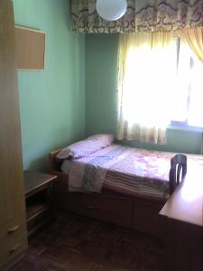 um pequeno quarto com uma cama e uma janela em HAB room 1 WIFI Vista Alegre em Madri