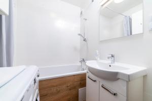 a white bathroom with a sink and a mirror at Apartament Gersona 4 in Bydgoszcz