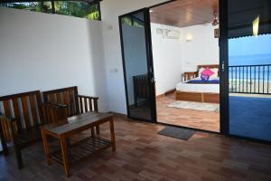 a room with a bedroom with a bed and a table at Madhu Huts Agonda in Agonda