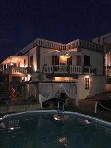 una grande casa bianca con piscina di notte di B&B Villa Delle Rondini a Vibo Valentia Marina